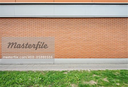 Empty brick wall and green grass ground.