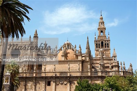 Detail of the gothic and baroque Cathedral of Seville and the famous bell tower called La Giralda that was previously a minaret of the Berber Almohad period in Spain.