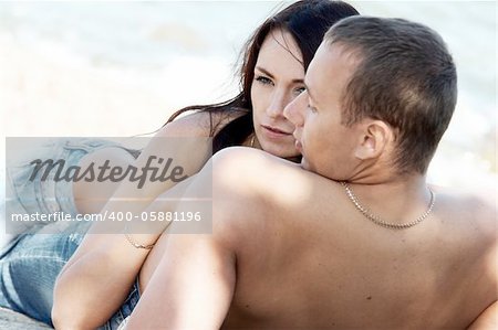 Sensual couple in jeans on a beach