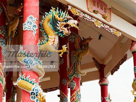 Left Golden dragon statue on red pillar in Chinese Temple style