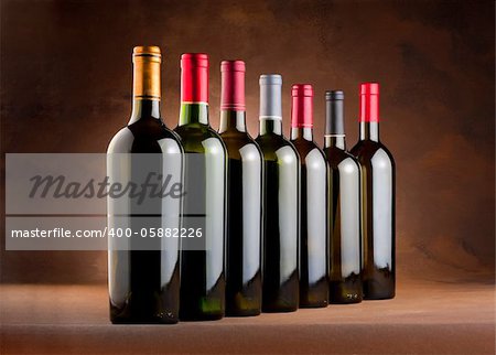 Red wine bottles in a row with empty labels on a mottled canvas background