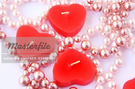 Heart shape red candles and necklace isolated on grey background.