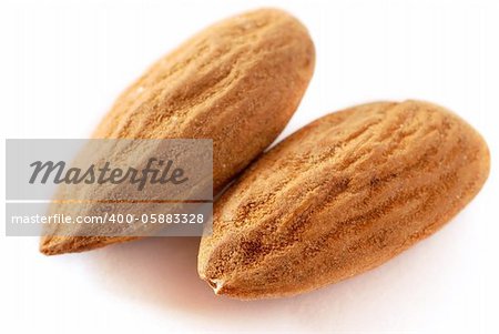 brown raw almonds over white background macro