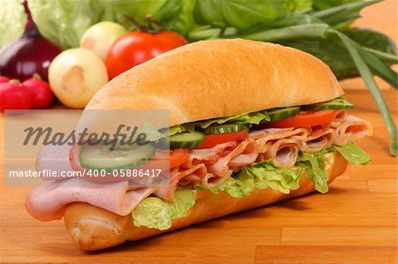Delicious ham, cheese and salad sandwiches on a wooden board