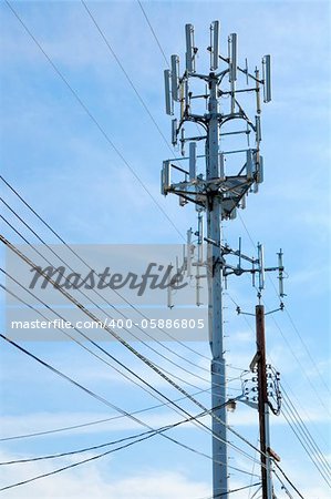 Cellphone tower showing multiple antennas against a blue sky