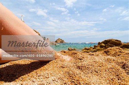 female legs on beach at sunny day