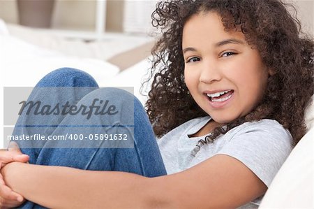 Studio shot of a beautiful young mixed race interracial African American girl child laughing smiling and showing off her perfect white teeth