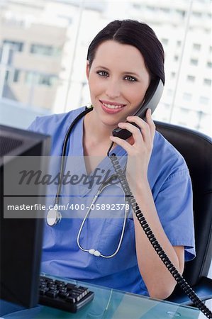 Portrait of a smiling female doctor on the phone in her office