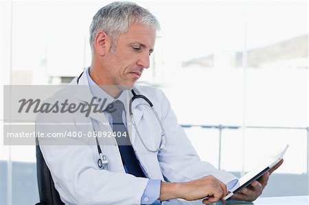 Doctor working with a tablet computer in his office