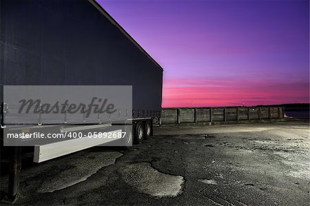 Truck trailer at the harbor with the sun's last colors in the background