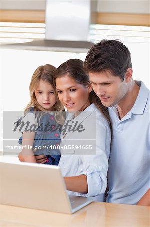 Portrait of a family using a laptop in their kitchen