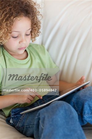 Portrait of a cute boy using a tablet computer in a living room