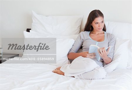 Woman holding a book in her bedroom