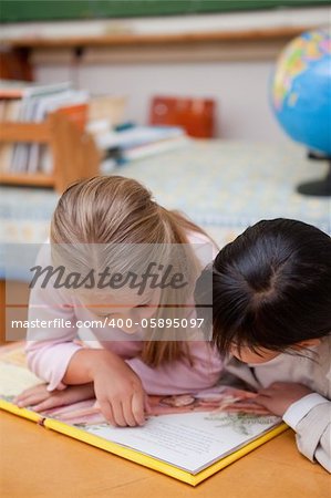 Portrait of focused schoolgirls reading a fairy tale in a classroom