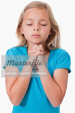 Portrait of a young girl praying against a white background