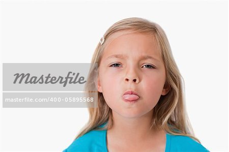 Girl sticking out her tongue against a white background