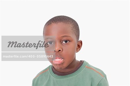 Boy sticking out his tongue against a white background