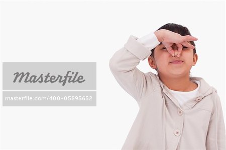 Girl pinching her nose against a white background