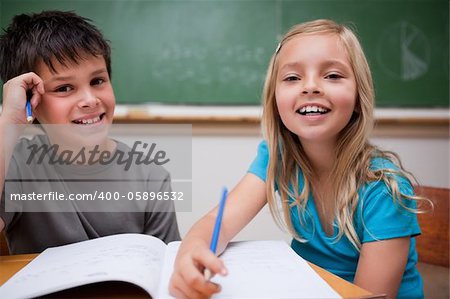 Two children writing in a classroom