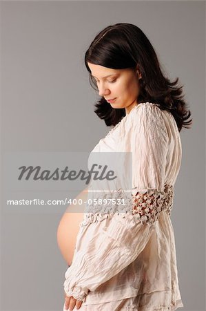 Portrait of a pregnant woman looking at her belly