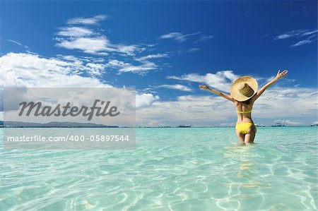 Girl on a tropical beach with outstretched arms
