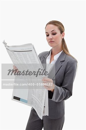 Portrait of a businesswoman reading the news against a white background