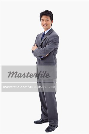 Portrait of a smiling businessman with the arms crossed against a white background