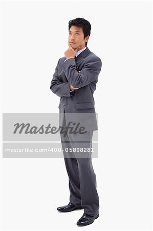 Portrait of a thoughtful businessman with the arms crossed against a white background