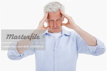 Tired man having a headache against a white background