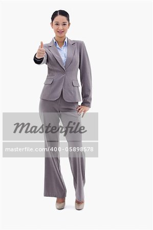 Portrait of a businesswoman posing with the thumb up against a white background