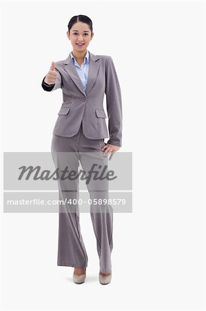 Portrait of a happy businesswoman posing with the thumb up against a white background