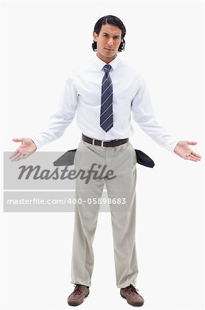 Portrait of an innocent businessman showing his empty pockets against a white background