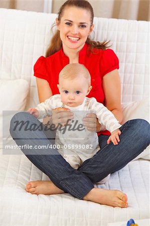 Adorable baby sitting on mothers laps