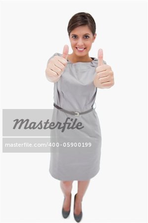 Smiling woman giving thumbs up against a white background