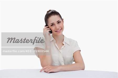 Smiling businesswoman making a phone call against a white background