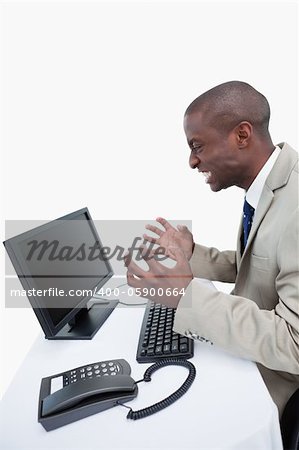 Side view of an angry businessman using a monitor against a white background