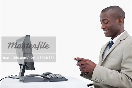 Side view of a smiling businessman sending a text message against a white background