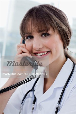 Portrait of a happy doctor on the phone in her office