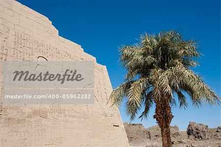 Egyptian hieroglyphic carvings on outer wall of the ancient temple at Medinat Habu in Luxor