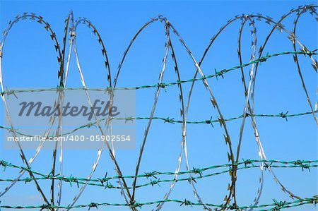 barbed wire against blue sky as nice army background
