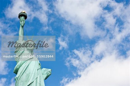 Sunnny day, blue sky with clouds: statue of Liberty with copy space