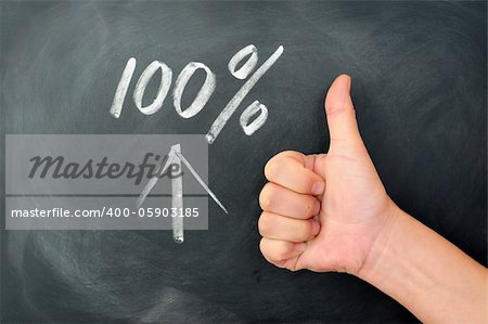 Thumb up with a 100 percent sign on a blackboard