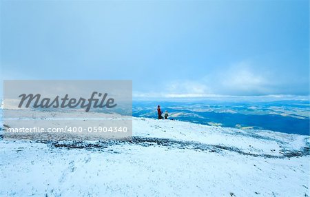 Family (mother with children) drink hot tea on autumn mountain plateau with first winter snow