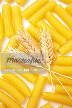 Pasta with wheat ears as background
