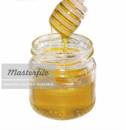 jar of honey with stick on white background