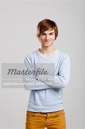 Portrait of a handsome young man standing over a gray background