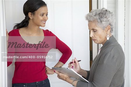 Black woman greeting a solicitor at her front door