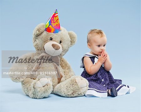 A little sweet girl with teddy in her first birthday.