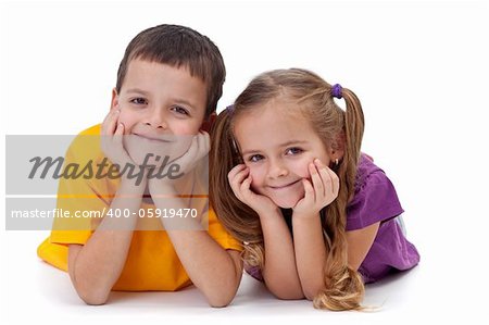Beautiful happy kids laying on the floor - boy and girl, isolated