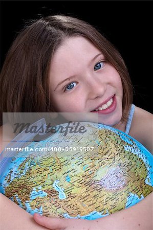 Young girl dreaming about a trip - holding a globe, closeup